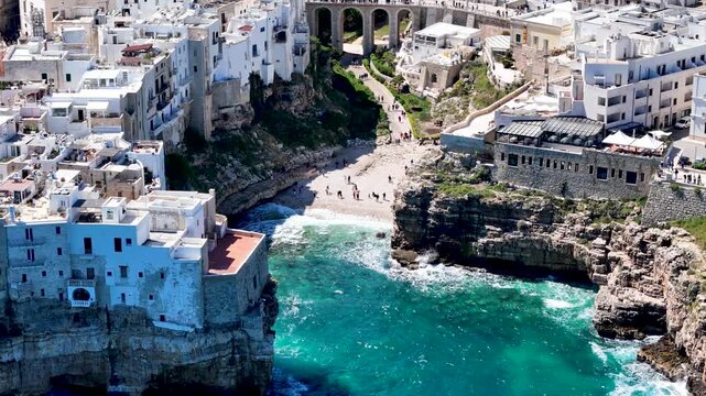 Polignano a Mare with Lama Monachile beach. Aerial 4K drone video footage with panorama view of stunning coastal townscape in Puglia, southern Italy