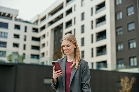 Young businesswoman using smartphone in modern city