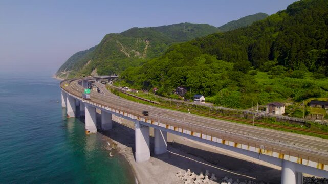 断崖の海岸線を貫く海上高架橋 橋脚の構造を捉えながら並走する前進空撮