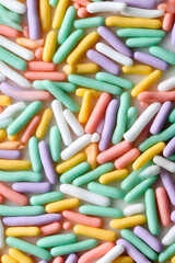 Colorful sugar sprinkles pattern background. Bright confectionery texture for bakery, party and dessert themed designs.