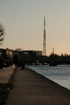 fishermen sitting on the pier at sunset