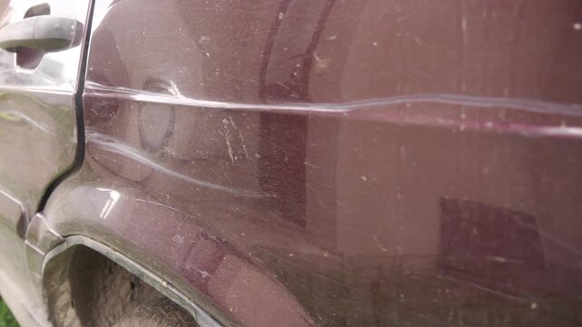 The car is damaged with scratches and dents.