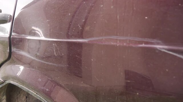 The car is damaged with scratches and dents.