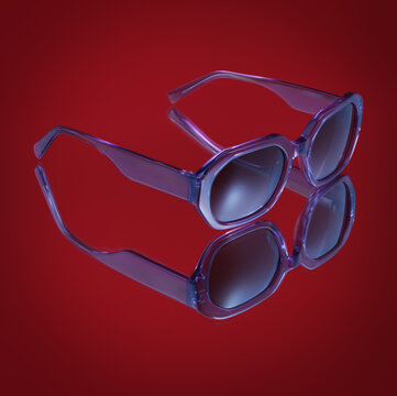 Minimalist purple translucent sunglasses reflecting on a glossy red background