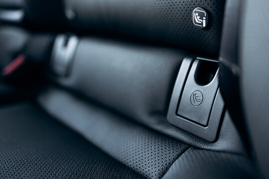 Isofix car seat anchor point on black leather seat, emphasizing child safety and modern automotive interior design