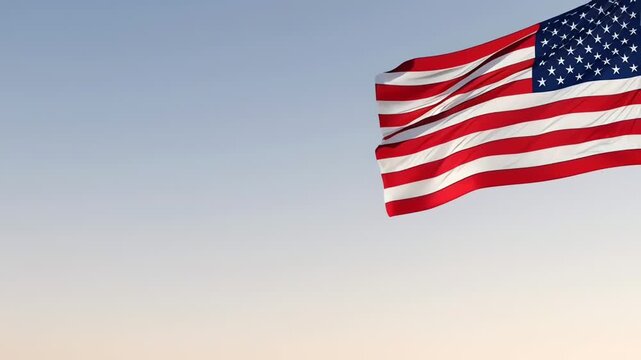 Waving American flag in top right corner against clear sky with large empty space. USA patriotic concept for presentation and advertising.
