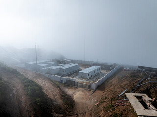 Fototapeta premium white container houses built on a mountain top shrouded in thick fog and mist