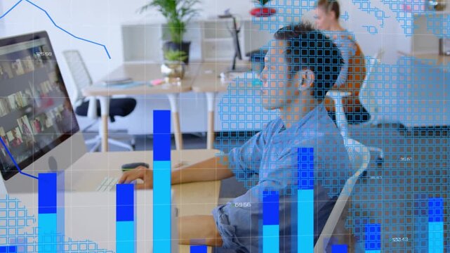 Man typing, clicking at desk, causing animated bar charts overlaying monitor to show finance trends