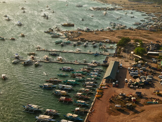 Aerial drone view of the floating fishing village in Coron, Palawan, Philippines. Traditional stilt houses, colorful rooftops, and Filipino outrigger boats line the coastal waters © akturer