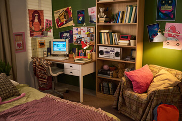 Wide shot of teenager bedroom featuring desktop computer, study desk, bookshelves, posters, expressing home learning and digital youth lifestyle. Ideal for education or teen marketing © pressmaster
