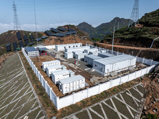 Fototapeta premium Energy storage container facility at a mountain photovoltaic power station with solar panels