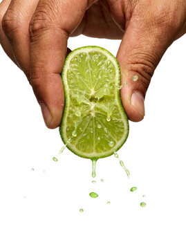 Hand squeezing a fresh lime with juice splashing, transparent background
