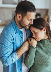 Fototapeta premium Comforting Couple Embracing In Kitchen, Man Consoles Woman Showing Support And Affection