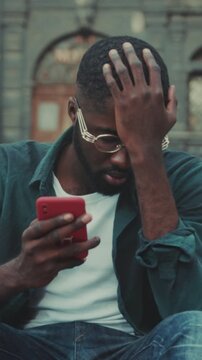 Anxious tourist reads urgent notifications carefully, Concerned traveler scans urgent messages amid busy city scene