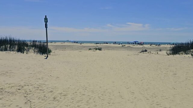  First person view (FPV)-Walking in sand-Approaching beach- Sullivan Island, SC already lined with sun seeking beach goers on one of the first warm spring days of the coming summer vacation season
