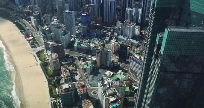 Haeundae beach, Busan, South Korea, aerial view with Busan bay, Songnim Park, Haeundae-gu district, white sand beach promenade, sea with Dongbaekseom Island, Gwangan bridge and Busan skyline panorama