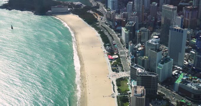 Haeundae beach, Busan, South Korea, aerial view with Busan bay, Songnim Park, Haeundae-gu district, white sand beach promenade, sea with Dongbaekseom Island, Gwangan bridge and Busan skyline panorama