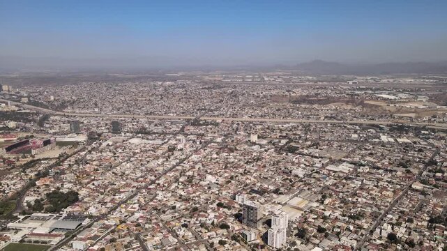 Vista a&eacute;rea de fraccionamientos residenciales, autopista urbana y colonias en los cerros de Tijuana, Baja California, M&eacute;xico