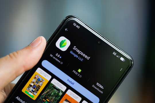 Close-up of a hand holding a smartphone displaying the Snapseed by Google LLC app on the Google Play Store