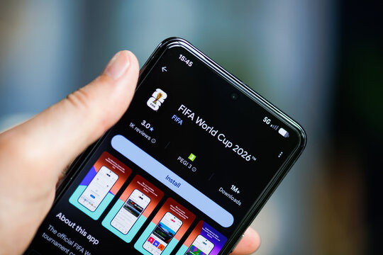 Close-up of a hand holding a smartphone displaying the FIFA World Cup 2026 app on the Google Play Store