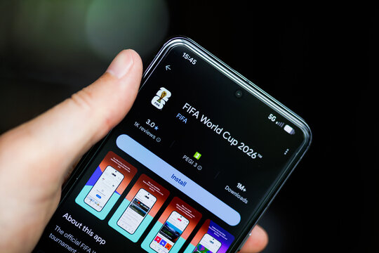 Close-up of a hand holding a smartphone displaying the FIFA World Cup 2026 app on the Google Play Store