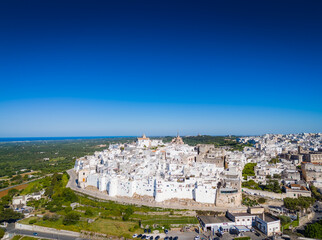 Obraz premium Ostuni, the White City of Puglia. Aerial drone view of panorama of historic Italian architecture and Mediterranean landscape. Whitewashed old town