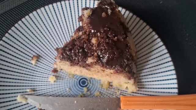 Delicious slice of chocolate cake on a patterned plate with a knife during breakfast time
