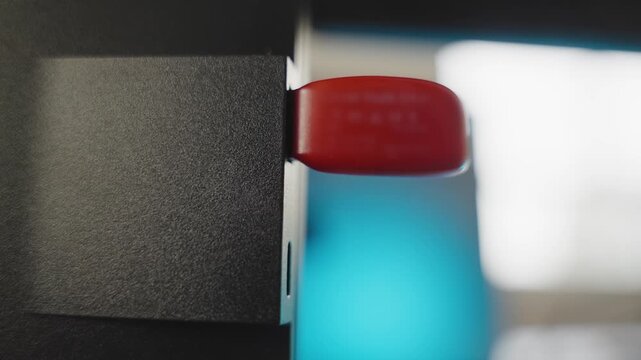 Extreme close up on computer as hand plugs memory flash drive and unplugs it. Installing software or app. Hacker or spy breaking into system with malware or spyware. Illegal tapping into private files