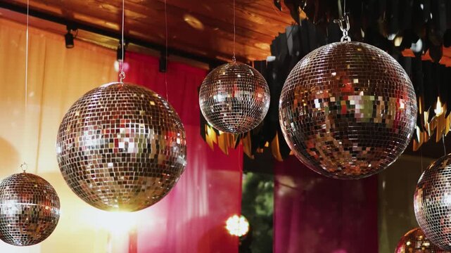 Disco balls wedding decor in 4k slow motion. Shiny mirror spheres hanging on ceiling for luxury party decoration, elegant marriage reception, anniversary celebration event venue or banquet hall.