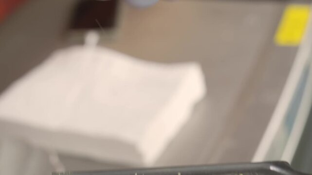 High-quality footage of a professional chef or home cook grating the rind of a bright yellow organic lemon using a handheld zester. The video captures the fine lemon peel falling onto the grater, high