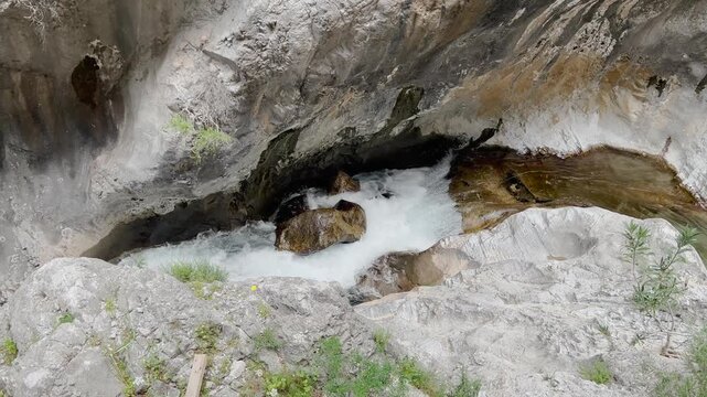 Wild mountain river stream rushing through colorful rocky canyon gorge