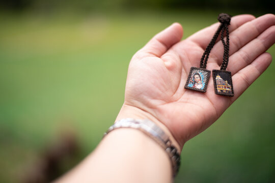 Catholic brown scapular hanging on light wall