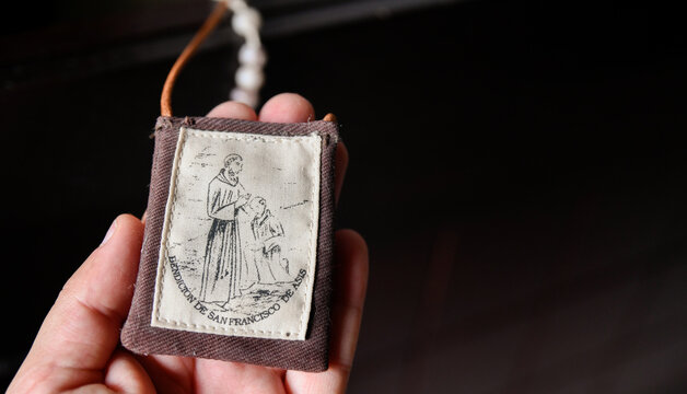 Hand holding Franciscan Catholic devotional scapular