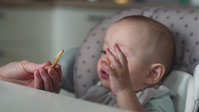 Baby refusing food crying in highchair during feeding time mealtime. Infant rejects eating solid food. Child refuses meal crying upset. Toddler won't eat dinner. Picky eater infant crying.