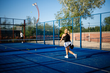 Obraz premium People playing padel on blue outdoor court