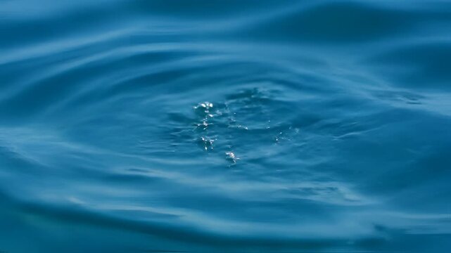 Closeup of Rippling Blue Water Surface with Sunlight Reflections.
