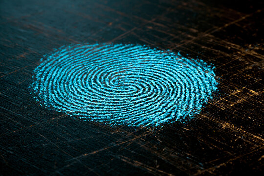 Glowing Cyan Fingerprint Evidence On Dark Scratched Surface