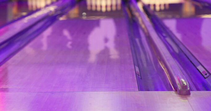 Bowling club play, group team of friends and colleagues playing, throwing a ball on the bowling alley lane, ball and pins, corporate party event in a mall amusement game center, tournament competition