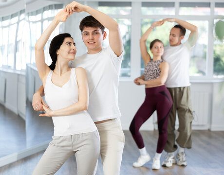 Young couple learns to dance pair disco fox during dance class in studio, repeat movements and learn act show. Studio school for amateur and professional dancers