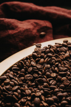 Granos de caf&eacute; reci&eacute;n tostados sobre charola dorada.