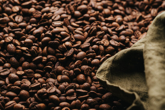 Granos de caf&eacute; reci&eacute;n tostados sobre charola dorada.
