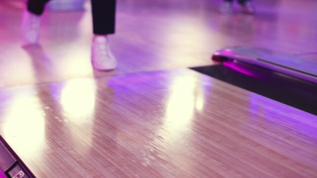 Bowling club play, group team of friends and colleagues playing, throwing a ball on the bowling alley lane, ball and pins, corporate party event in a mall amusement game center, tournament competition