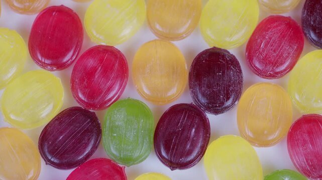 Colorful candies and chocolates arranged extravagantly on smooth flat surface. Vibrant assortment of sugarcoated confections artistically spread out on level surface for display