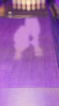 Bowling club play, group team of friends and colleagues playing, throwing a ball on the bowling alley lane, ball and pins, corporate party event in a mall amusement game center, tournament competition