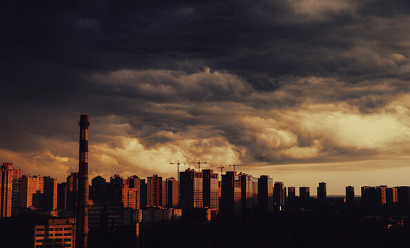 An incredible sunset in the big city and storm clouds hanging over the high-rise buildings
