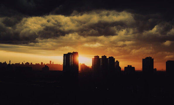An incredible sunset in the big city and storm clouds hanging over the high-rise buildings