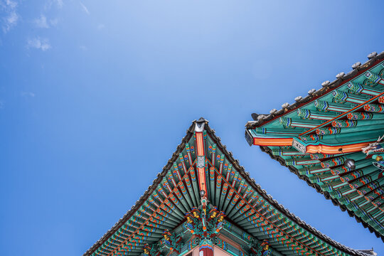 Low angle view of traditional dancheong patterns on the colorful wooden eaves of an ancient korean building