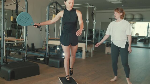 Female pilates instructor guiding woman during training session