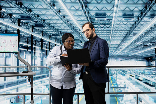 Microelectronics smart factory directors using EDA software to optimize production lines workflows. Businesspeople using program to track CPU parts production performance