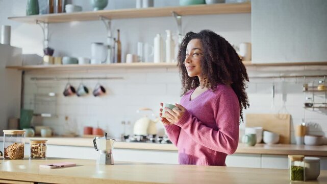 Dreamy woman holding coffee cup standing modern kitchen interior closeup. 